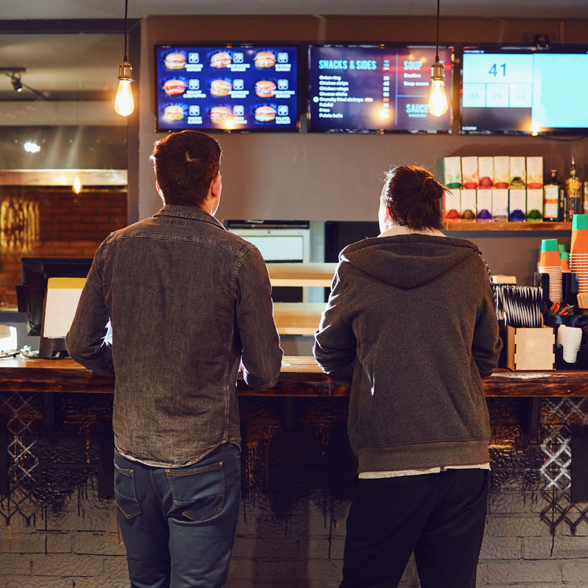 Two men waiting to be served at a restaurant